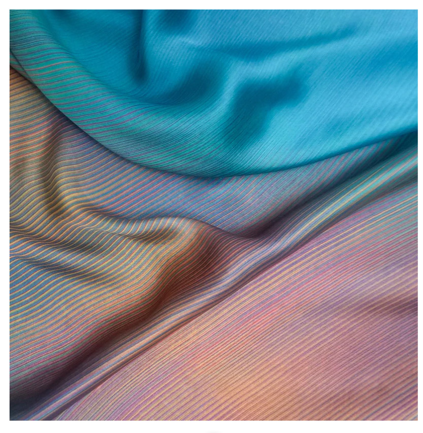Viscose silk with a minimalistic print of warm colored lines on a turquoise ground