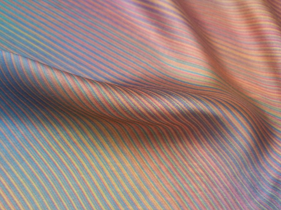 Viscose silk with a minimalistic print of warm colored lines on a turquoise ground